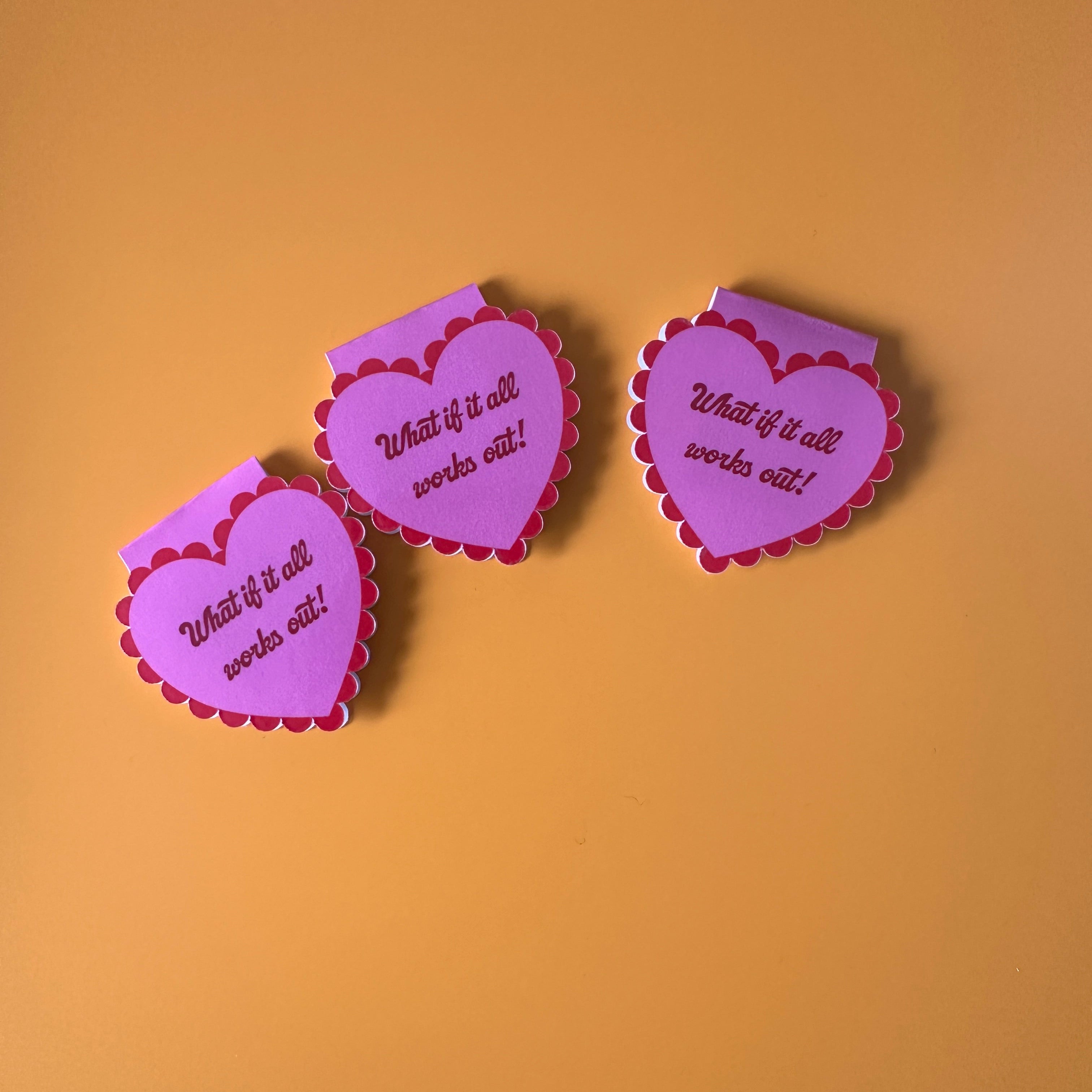 "Mauve scalloped heart corner bookmark with pink trim and the hand-lettered affirmation 'What if it all works out!'"