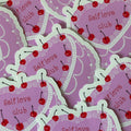 "Glossy pink die-cut vinyl sticker shaped like a cherry-topped cake with pearl trim and the words 'Self love club'"
