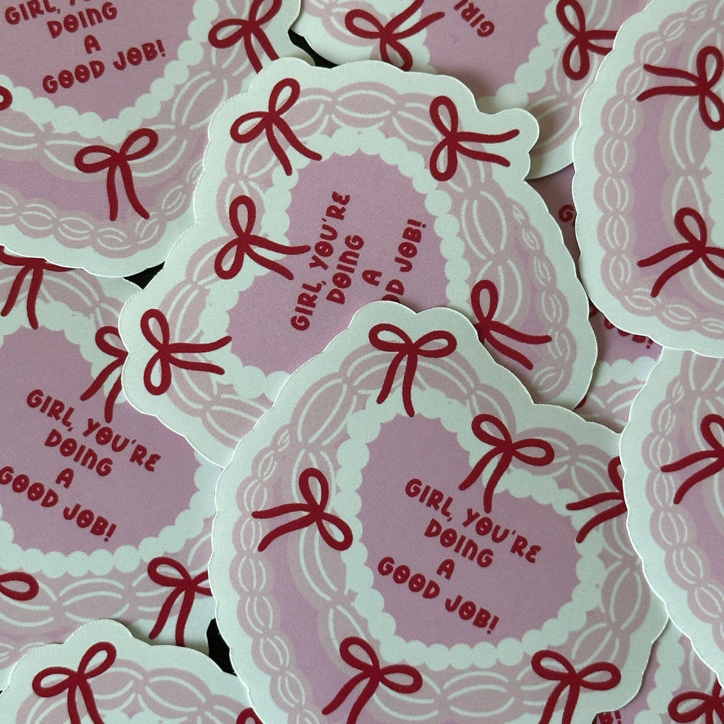 "Glossy pink heart-shaped vinyl sticker bordered with red bows and the message 'Girl, you're doing a good job!'"