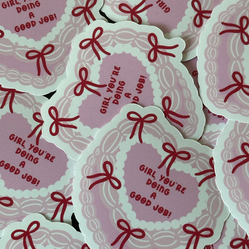 "Glossy pink heart-shaped vinyl sticker bordered with red bows and the message 'Girl, you're doing a good job!'"